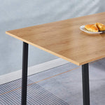 150cm office desk workstation with wooden surface and a plate of pastries on top.