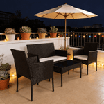 Patio Furniture Set 4 Piece PE Rattan arranged on a balcony with an umbrella, potted plants, and decorative lights.