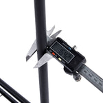 Digital caliper measuring a black metal rod on a white background | Artisansa SA