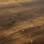 Close-up of a textured wooden surface with visible grain and imperfections.| Artisansa SA