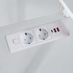 Close-up of built-in AC power outlets and USB charging ports on desktop