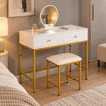 White dressing table with round mirror and stool beside a bed