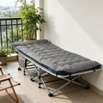 Portable folding camping cot with mattress used for relaxing on home balcony