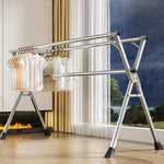 Foldable Clothes Rail shown in a modern home, displaying folded garments on a stainless steel X-frame.