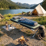 Heavy-Duty Portable Folding Camping Stretcher set up by a serene lake with camping gear and a cozy fire.