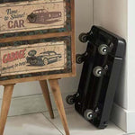 Foldable Hand Truck with 6 wheels leaning against a vintage garage-themed cabinet.