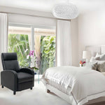 Stylish manual recliner chair in modern bedroom with white decor and tropical view.