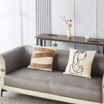 Narrow Sofa Table with Charging Station behind a cozy couch decorated with unique pillows and a vase of flowers.