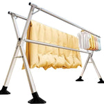 Foldable Clothes Rail – Stainless Steel X-Frame with clothing hanging and quilts drying.