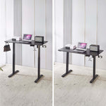 Electric Standing Desk in black, adjustable height with laptop and speaker, ideal for ergonomic workspace.