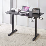 Electric Standing Desk Black Adjustable 120cm with laptop and speaker on top, ideal for ergonomic workspaces.