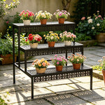 Black 3-tier metal flower pot stand displaying plants on a garden patio
