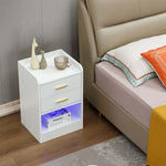 Modern LED Pedestal beside a bed, featuring two drawers and a stylish open shelf with LED light.