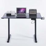 Electric Standing Desk black adjustable with laptop, books, and speaker, designed for ergonomic comfort.