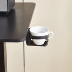 Electric Standing Desk cup holder with a white coffee mug for ergonomic workspace convenience.