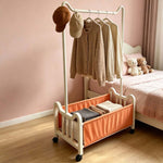 Steel Clothing Rack with shelves and wheels holding clothes and hats in a stylish bedroom.
