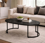 Oval Black Marble Coffee Table with decorative bowl and books in a stylish living room setting