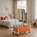 Steel Clothing Rack with Shelves & Wheels in a cozy bedroom displaying hanging clothes and neatly folded towels.