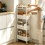 A person organizing a 4-Tier Rolling Storage Cart in a modern kitchen, showcasing its functionality and design.