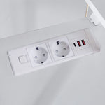 Close-up of built-in AC power outlets and USB charging ports on desktop