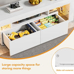 Open white TV stand drawers displaying games, controllers and media accessories