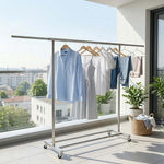 Double Rail Retractable Clothes Rack with Wheels displaying various hanging clothing items in a modern outdoor setting.