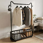 Freestanding Clothes Rack with hanging clothes, shelf, and lockable wheels in a stylish bedroom setting.