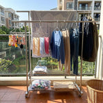 Double Rail Clothes Rack with Shoe Shelf featuring hanging garments and organized space on a balcony.
