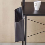 Modern computer desk accessory with a gray storage pocket hanging beside a desk and a white cup on top.