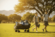 Person pulling a black folding wagon loaded with camping gear across a park lawn - best folding wagon South Africa