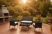 Black PE rattan 4-piece outdoor patio set with white cushions on a South African garden deck at golden hour - ArtisanSA