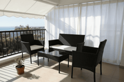 Outdoor furniture South Africa – 4-Piece Rattan Patio Set with cushions and glass table in sunny outdoor setting - ArtisanSA