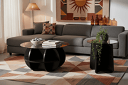 A round glass coffee table set with a black wooden frame, for a modern South African living room.