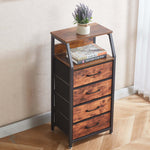 Wooden side table with drawers and a plant on a wooden floor.