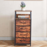 Wooden dresser with four drawers and a small plant on top against a beige wall.