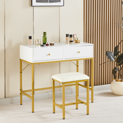 Compact white vanity table with gold frame and stool in a contemporary bedroom