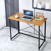 Minimalist Computer Desk with X-Frame Design, featuring a laptop and cup on a wooden surface in a modern setting.