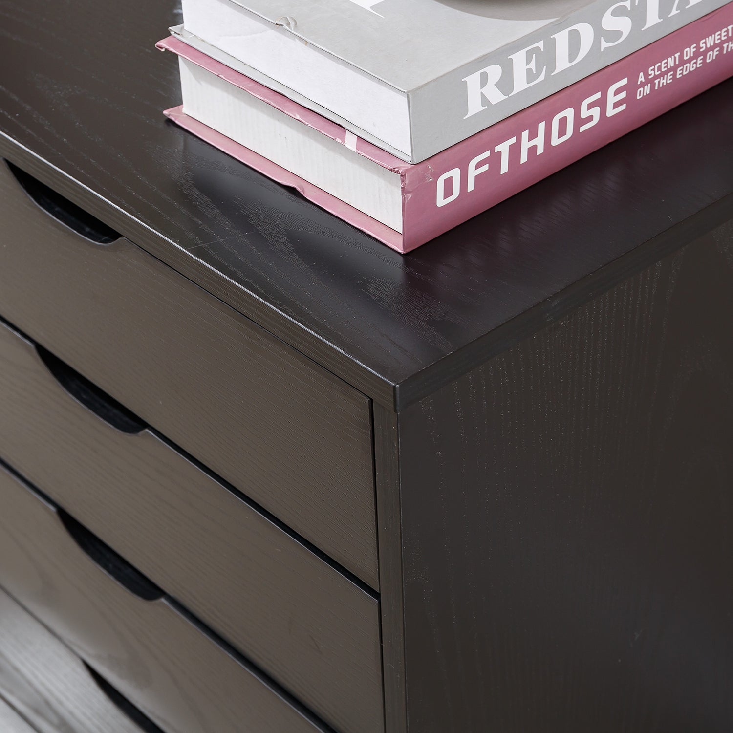 Top view of a Black Bedside Table with Drawers, featuring books stacked on top.