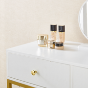White dressing table drawers with gold knobs and cosmetics