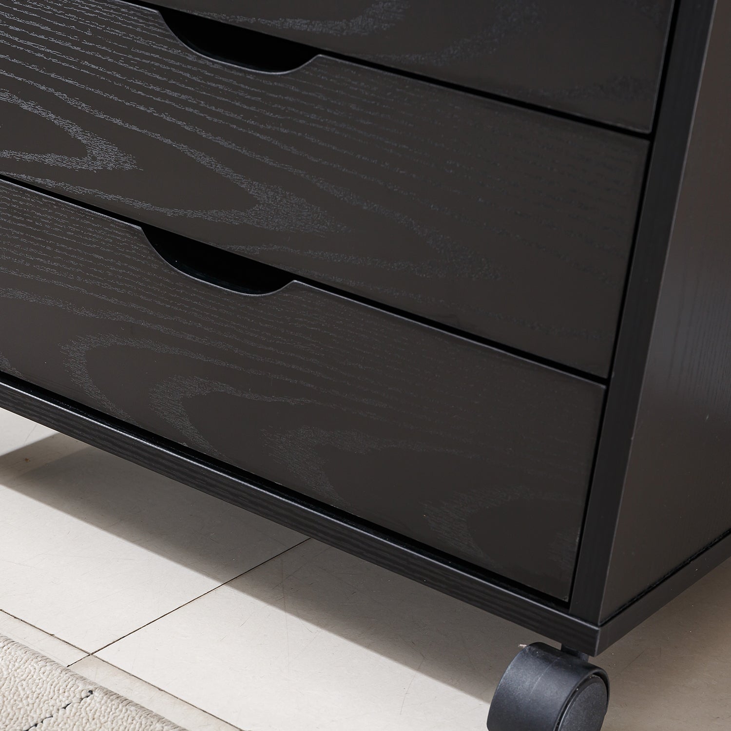 Close-up of Black Bedside Table with Drawers, showcasing the sleek design and three spacious drawers on wheels.
