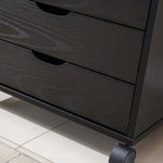 Close-up of Black Bedside Table with Drawers, showcasing the sleek design and three spacious drawers on wheels.