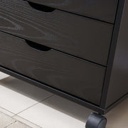 Close-up of Black Bedside Table with Drawers, showcasing the sleek design and three spacious drawers on wheels.