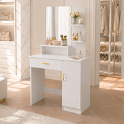 A white vanity table with an attached mirror, open shelf, and cabinet, styled in a bright, modern dressing room.