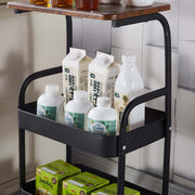 3-Tier Rolling Storage Cart with Wood Top displaying bottles and containers for organized storage in a stylish kitchen.