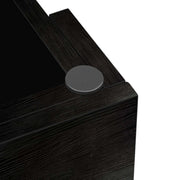 Close-up of a black textured surface with a circular metallic object on a white background| Artisansa SA