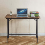 compact computer desk for students with laptop, books, and plant on tabletop in a small space.