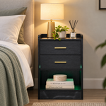 Black bedside table with open shelf and green LED lighting beside a bed
