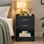 Black bedside table with open shelf and green LED lighting beside a bed