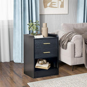 Black bedside table with gold handles styled beside a grey bed