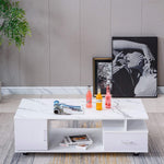 Modern living room with a white coffee table, drinks, and framed pictures on a gray wall. | Artisansa SA